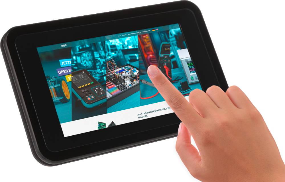 Une main touche l'écran d'une tablette sur laquelle on peut voir un site web présentant des appareils électroniques et des schémas de circuits.