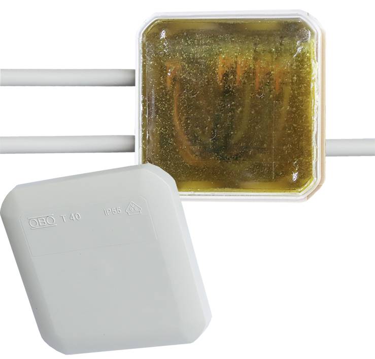 Une boîte de connexion transparente montre à l'intérieur une substance résineuse. À côté se trouve un élément de boîtier amovible portant l'inscription 'OBO T40 IP65'.