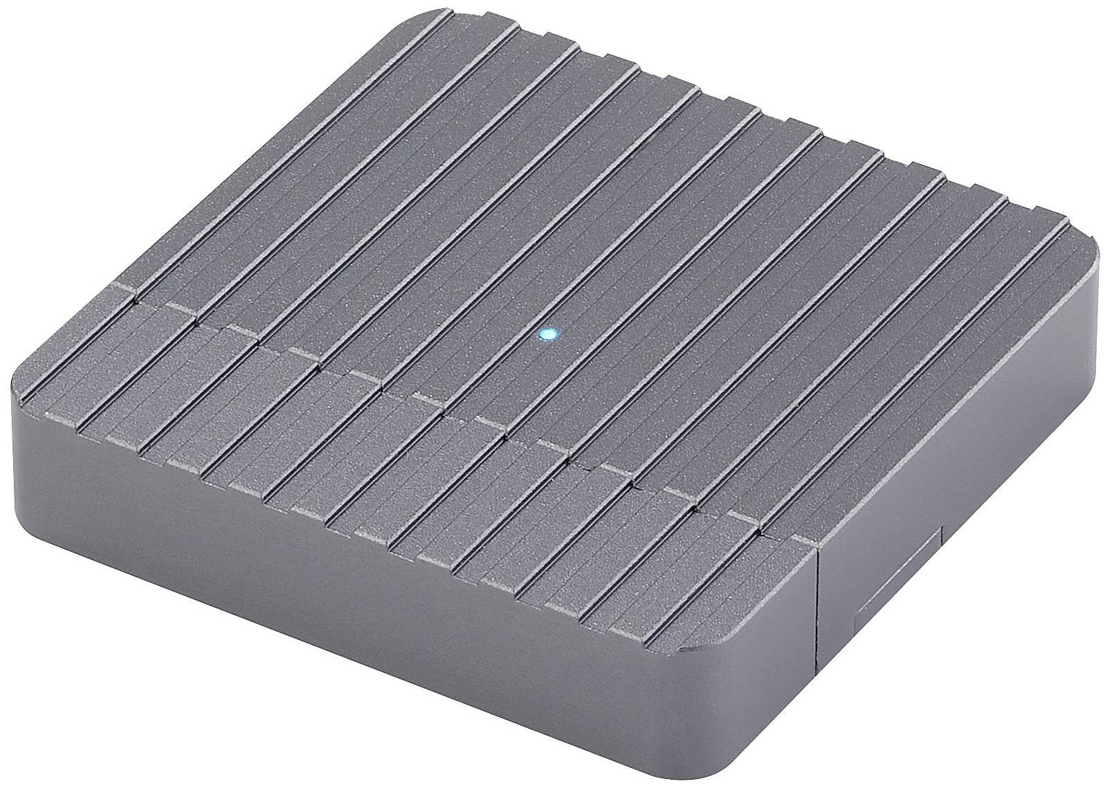 Un appareil gris, carré, à surface cannelée et doté d'un petit voyant bleu au centre. Probablement un appareil électronique.