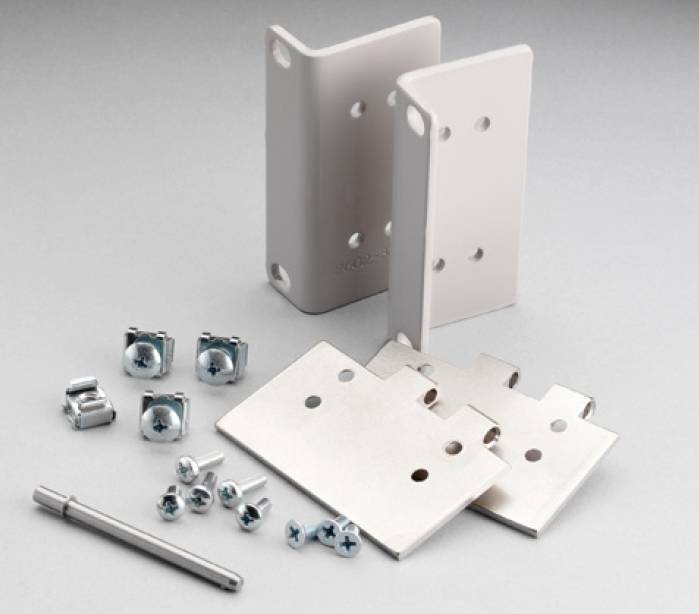 Ensemble de montage avec composants métalliques, vis, écrous et outils, destiné à la fixation d'appareils électroniques dans des boîtiers.