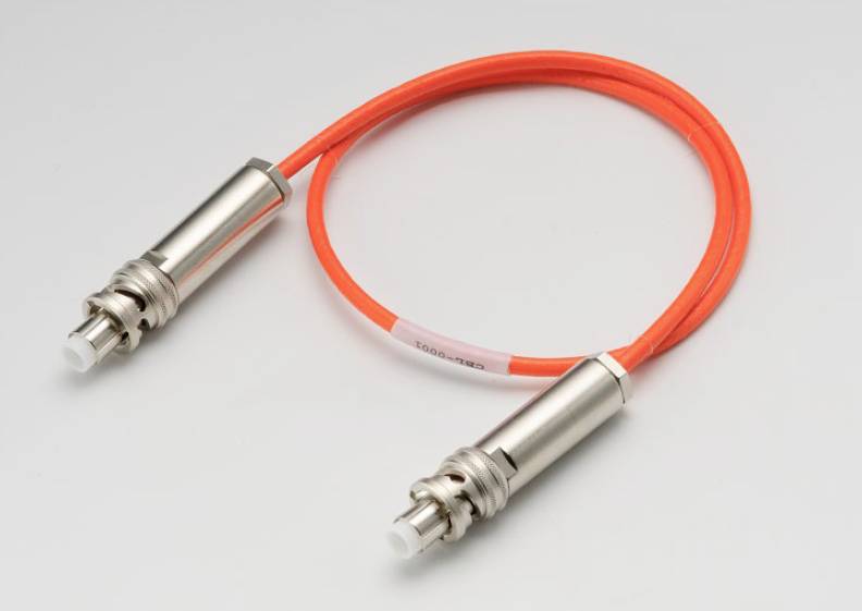 Un câble à fibre optique orange avec deux connecteurs argentés à ses extrémités, sur un fond gris.