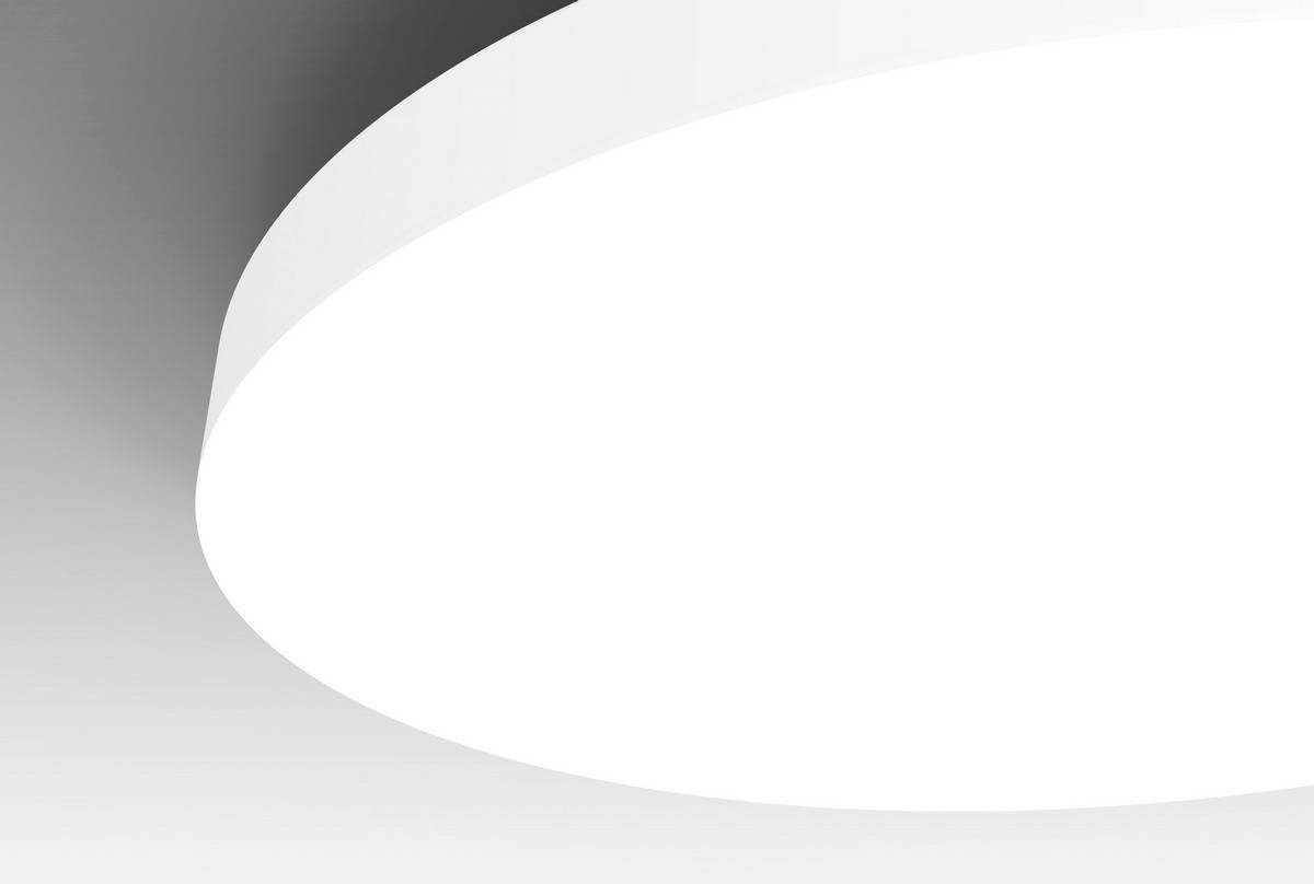 Grande lampe de plafond blanche illuminant une pièce moderne. Sa forme ronde est lisse et épurée, entourée d'ombres grises.