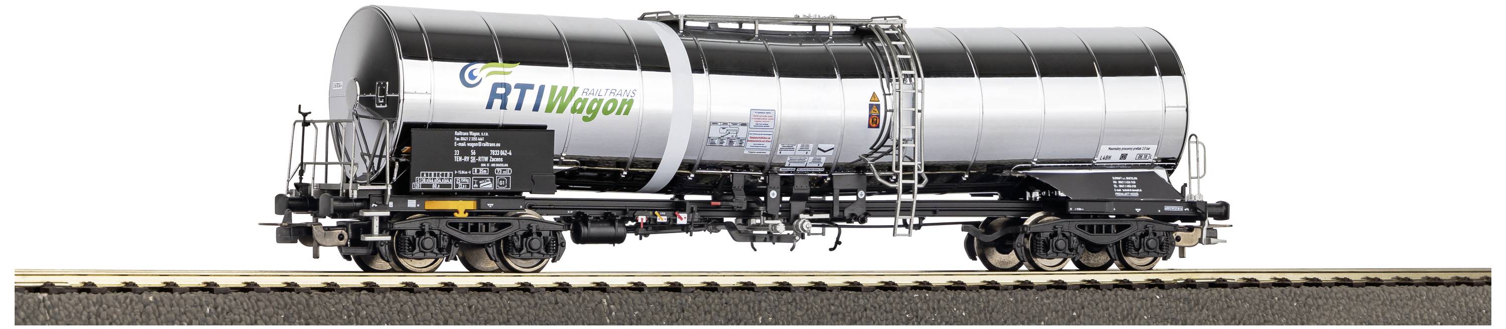 Un wagon-citerne argenté portant l'inscription 'RTI Wagon' circule sur une voie ferrée.