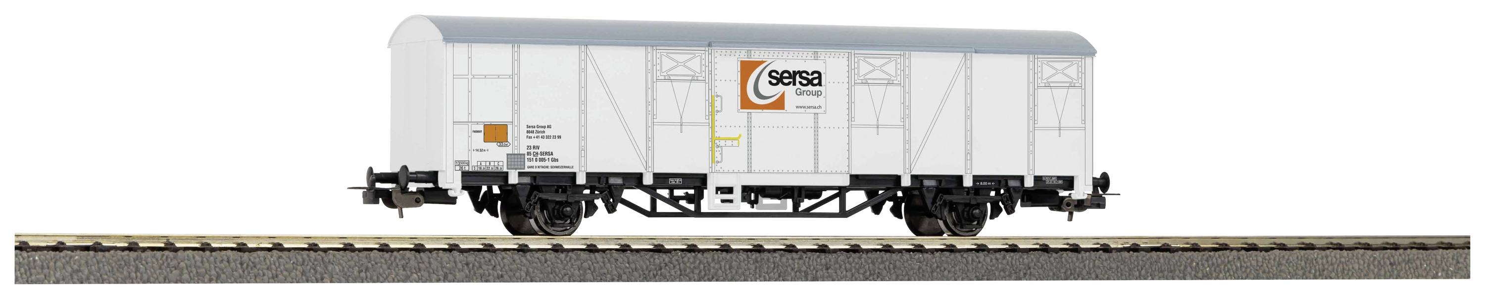 Un wagon de marchandises blanc sur une voie ferrée. Le wagon porte le logo du 'Groupe Sersa'.