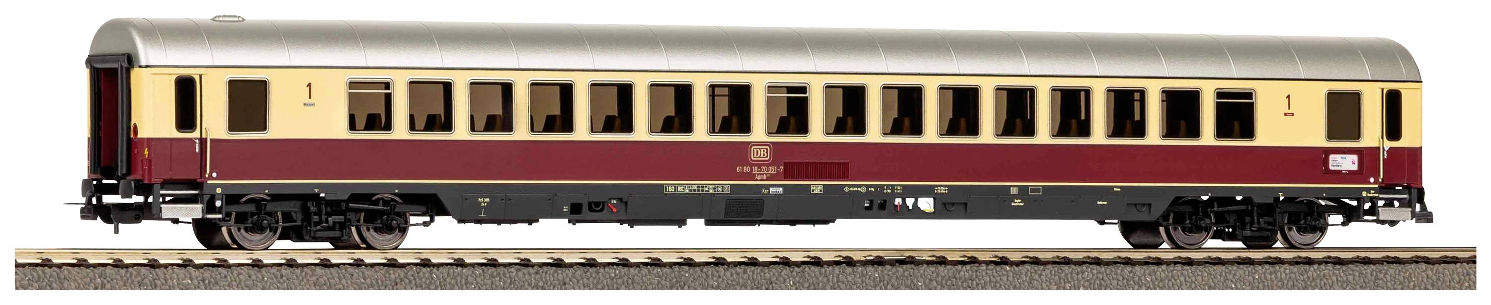 Une voiture de train rouge crème est stationnée sur une voie ferrée. La voiture possède une peinture bicolore et plusieurs fenêtres.