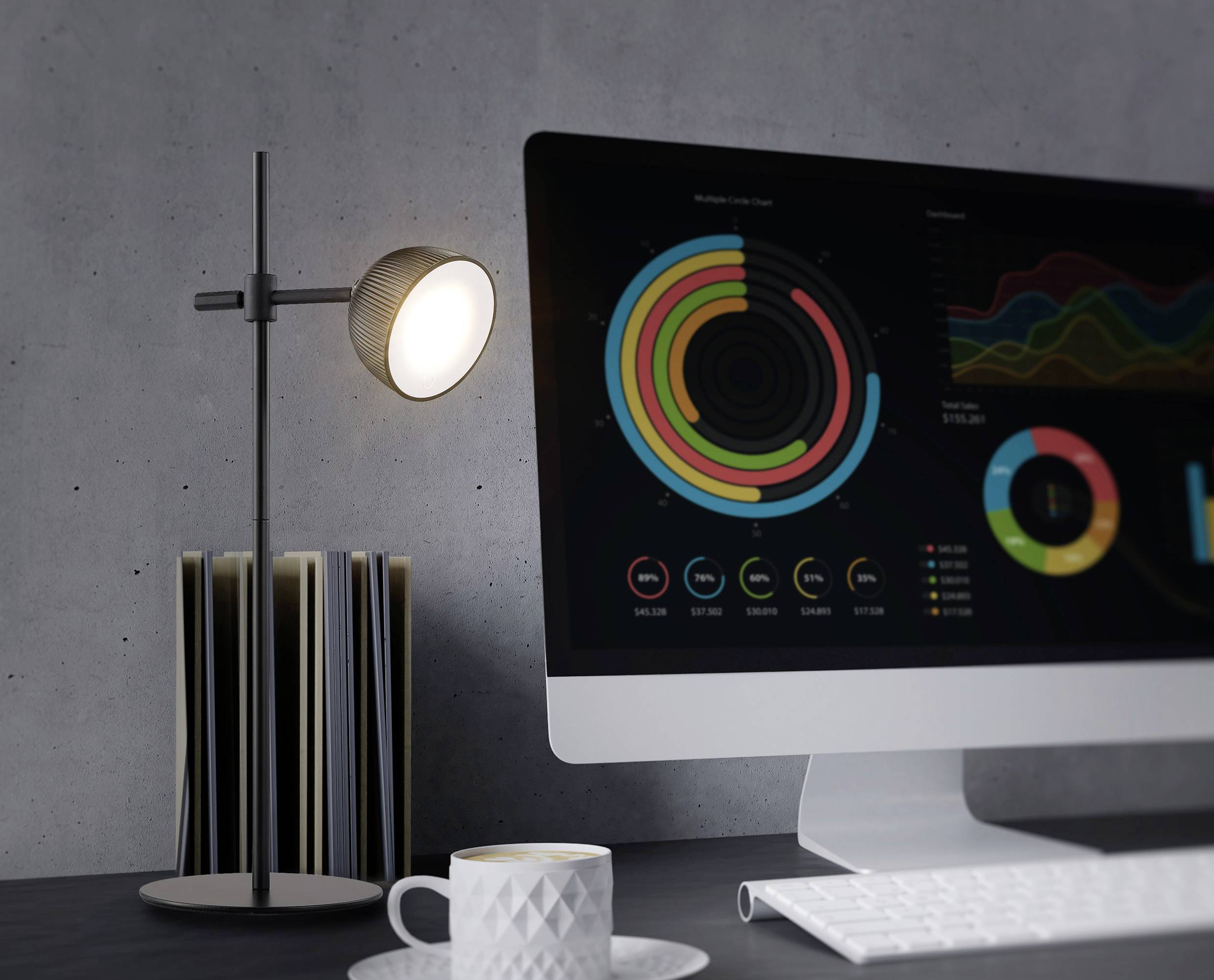 Un écran d'ordinateur affiche des diagrammes colorés en cercles et en lignes. Une lampe brille à côté, et une tasse de café est posée sur la table.