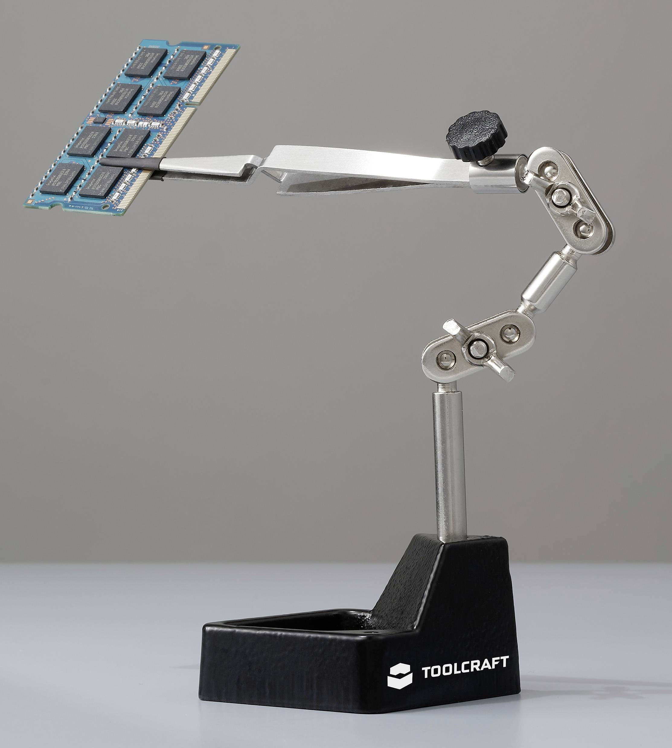 Un outil d'aide au soudage de TOOLCRAFT maintient un ensemble de puces mémoire dans un bras préhenseur mobile. Idéal pour des travaux électroniques précis.