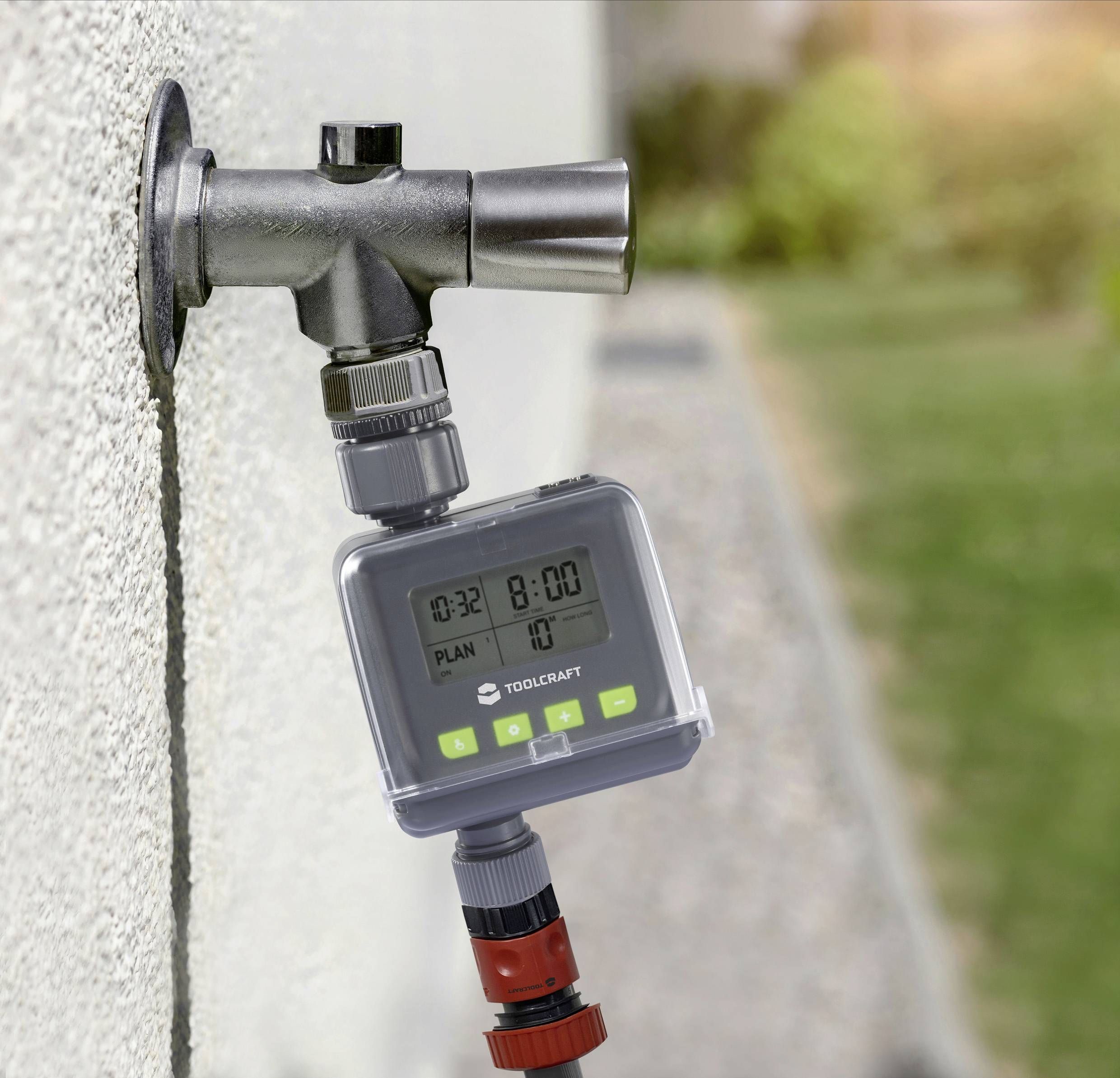 Un minuteur d'irrigation numérique est installé sur un robinet d'eau extérieur. Le minuteur affiche l'heure '8:00' et 'Plan 10'.