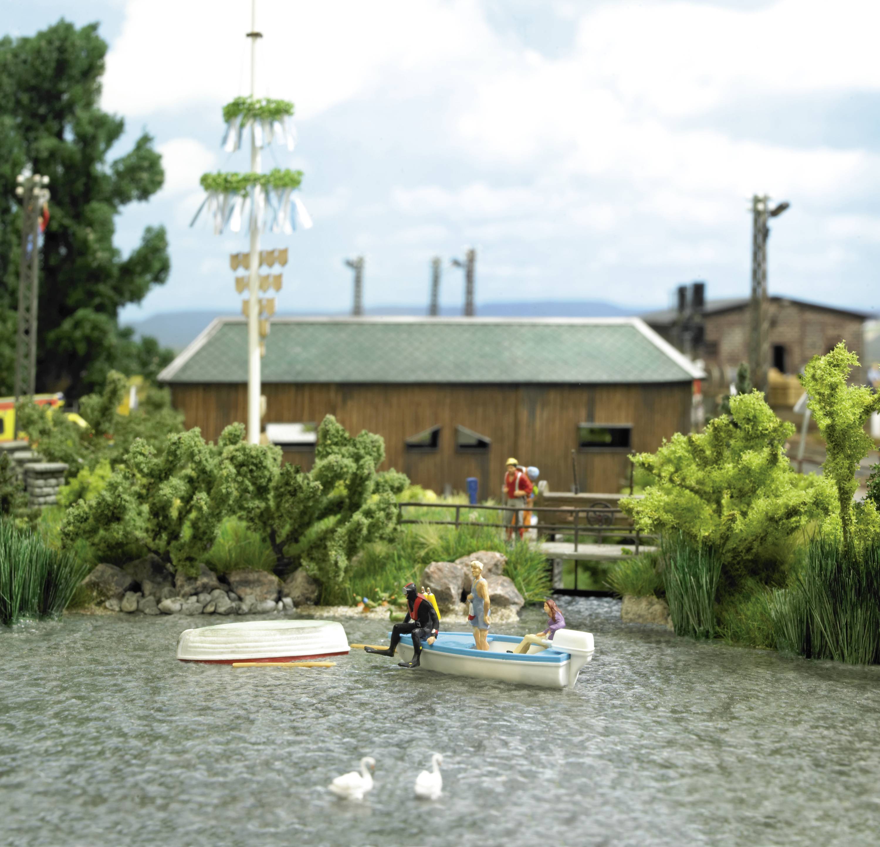 Un lac avec deux canards, un bateau chaviré et un autre bateau avec des personnes. En arrière-plan, on peut voir des arbres et un bâtiment.