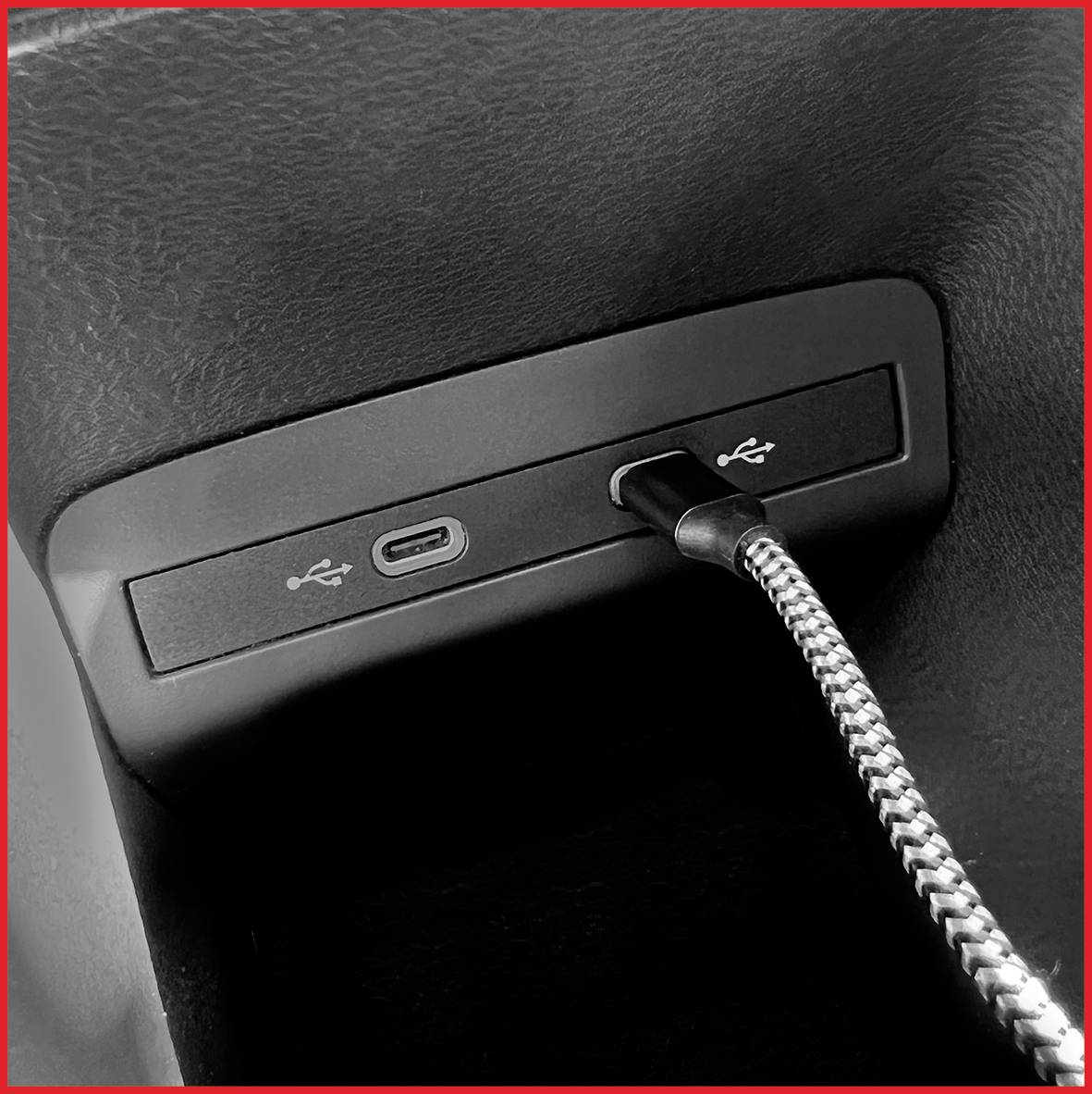 Connexion USB dans une voiture avec un câble tressé branché vers un port USB-C.