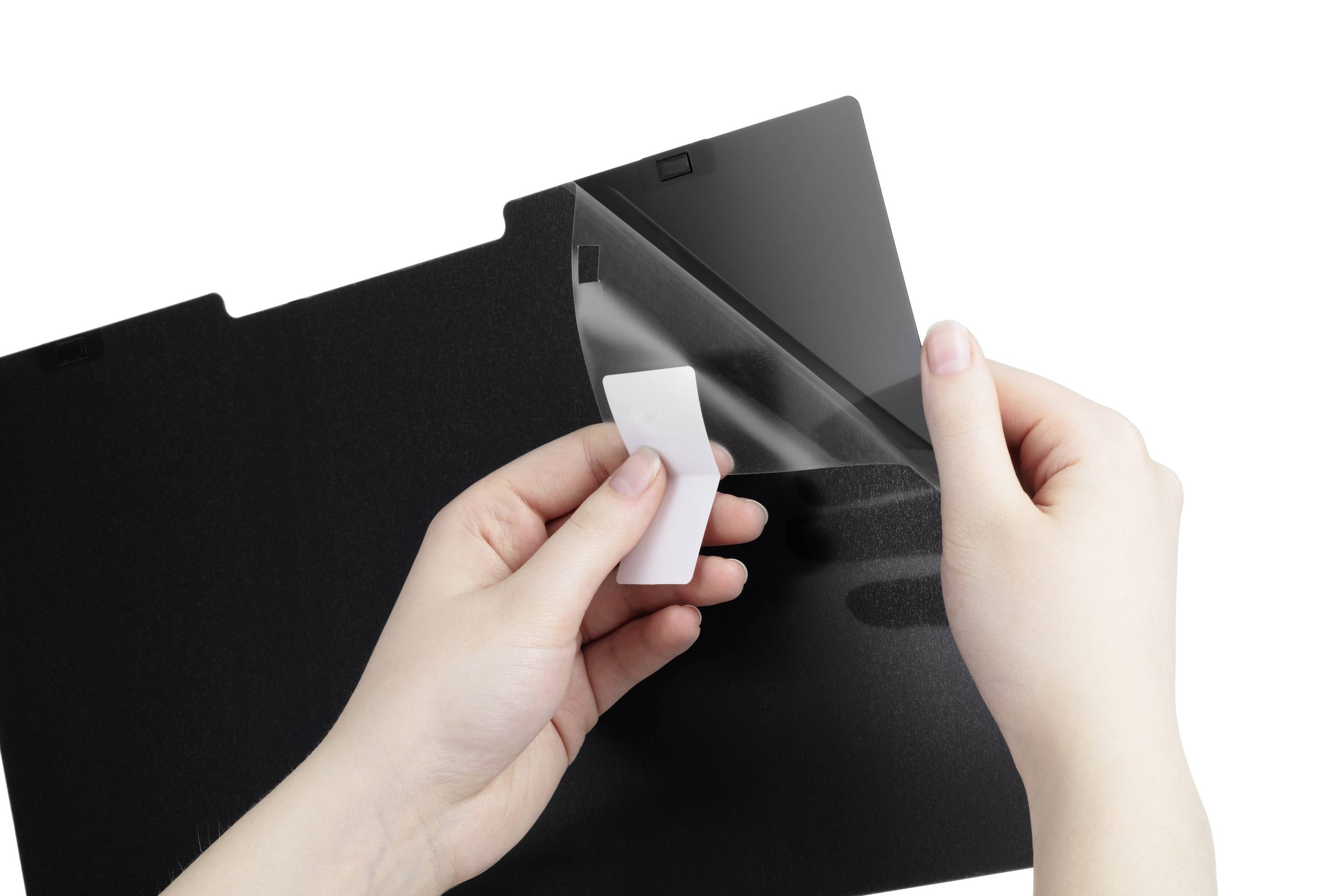 Des mains retirent un film de protection d'un filtre d'écran noir.