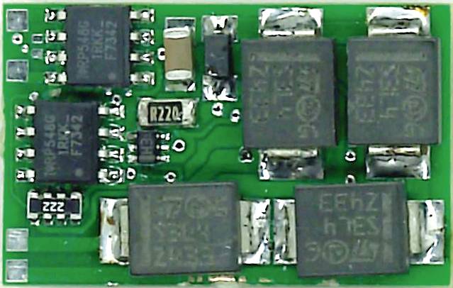 Une carte électronique verte avec plusieurs composants électroniques noirs, incluant des résistances et des condensateurs, soudés.