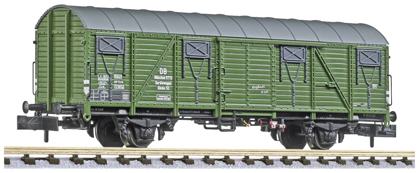 Wagon de marchandises vert sur un modèle de voie ferrée ; montre les détails des portes, fenêtres et inscriptions ; représenté à l'échelle du modèle.