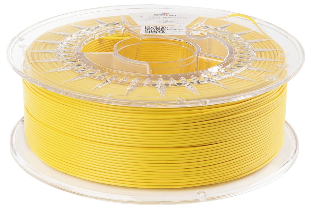 Bobine de filament jaune pour imprimante 3D sur un support en plastique transparent. Optimale pour la modélisation et le développement de prototypes.