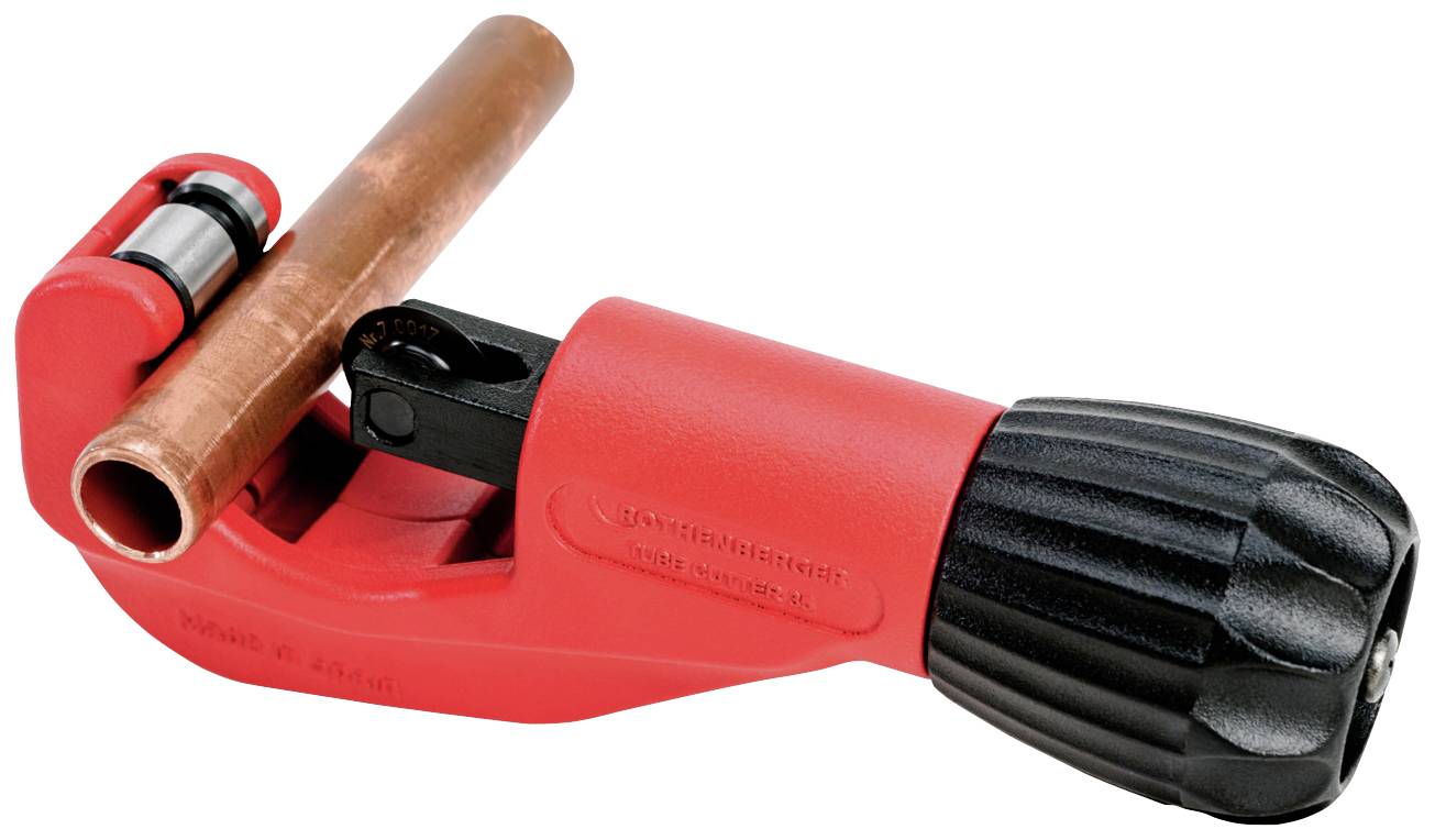 Un coupe-tube rouge avec une poignée noire maintient un tuyau en cuivre.