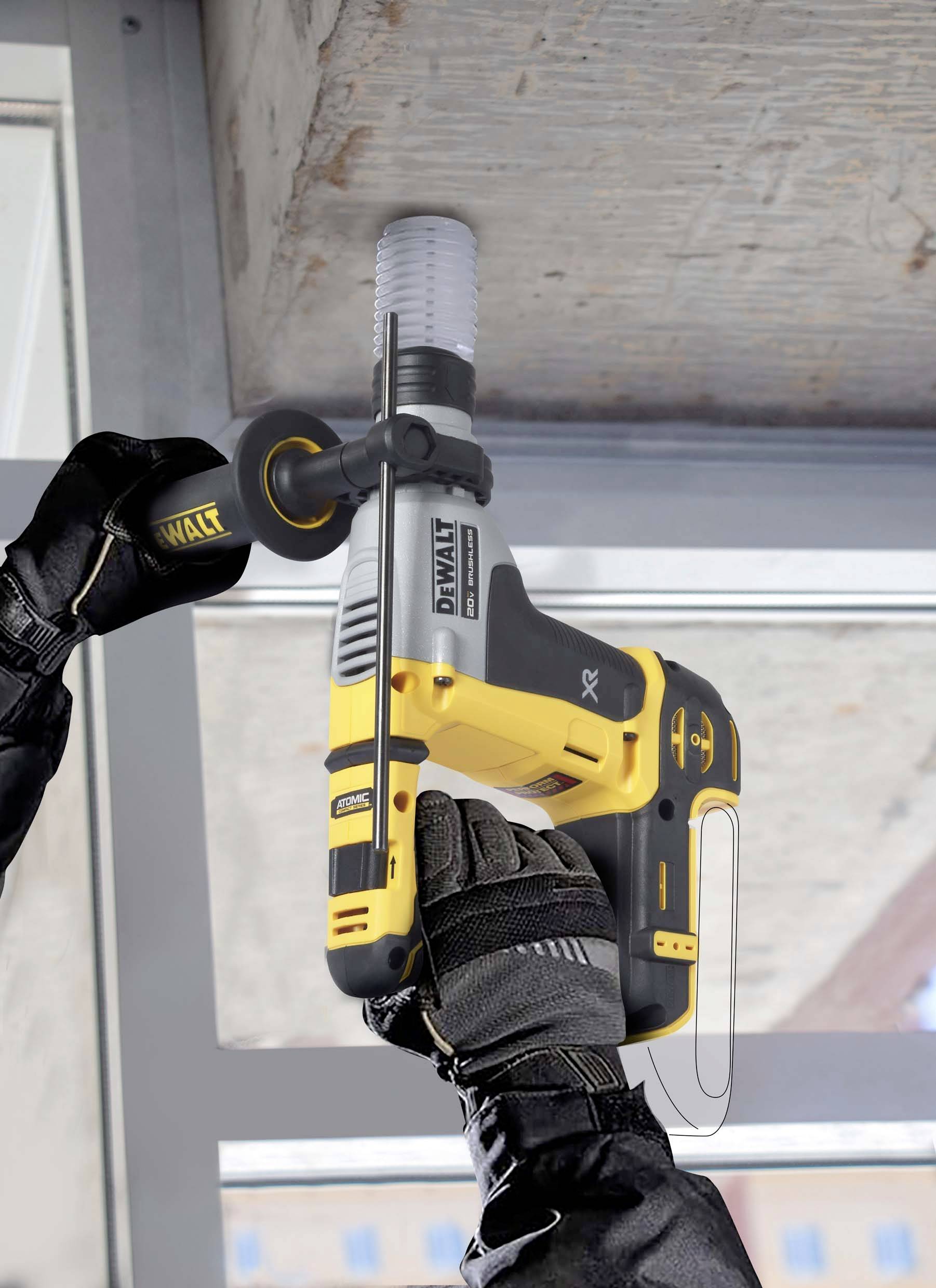 Une personne fore un bloc de béton à l'aide d'une perceuse électronique jaune. La personne porte des gants noirs.