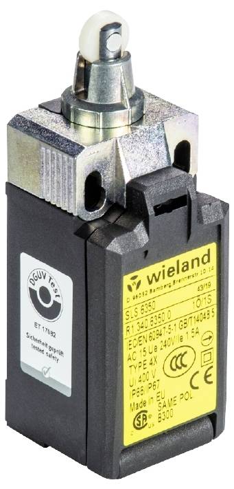 Un interrupteur de sécurité noir avec une étiquette jaune et une tête de commutation argentée. Marquage 'wieland' et indication de la classe de protection IP67.