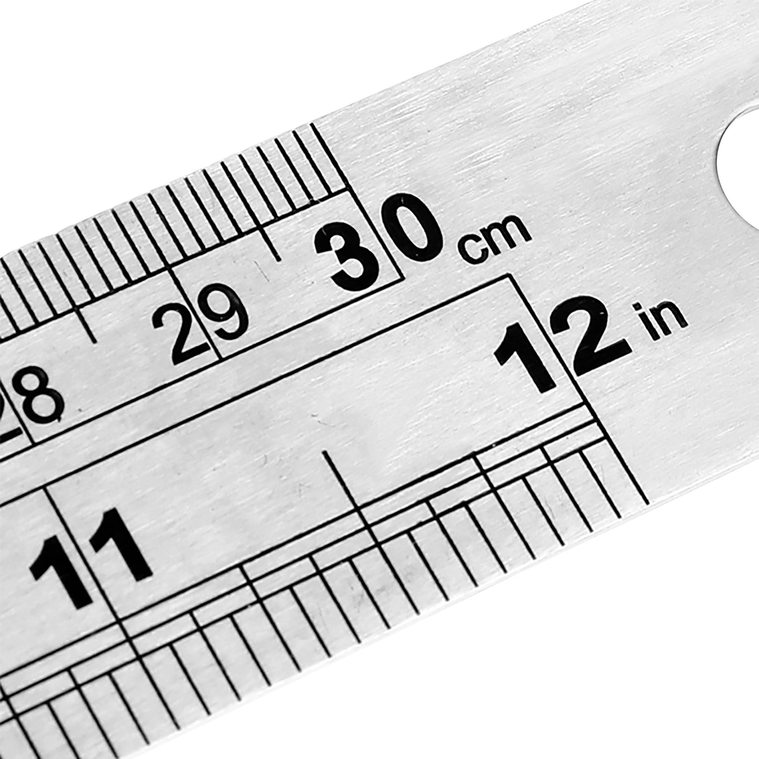 Règle métallique avec échelle en centimètres et en pouces. Indique des marquages de 30 cm et 12 pouces.