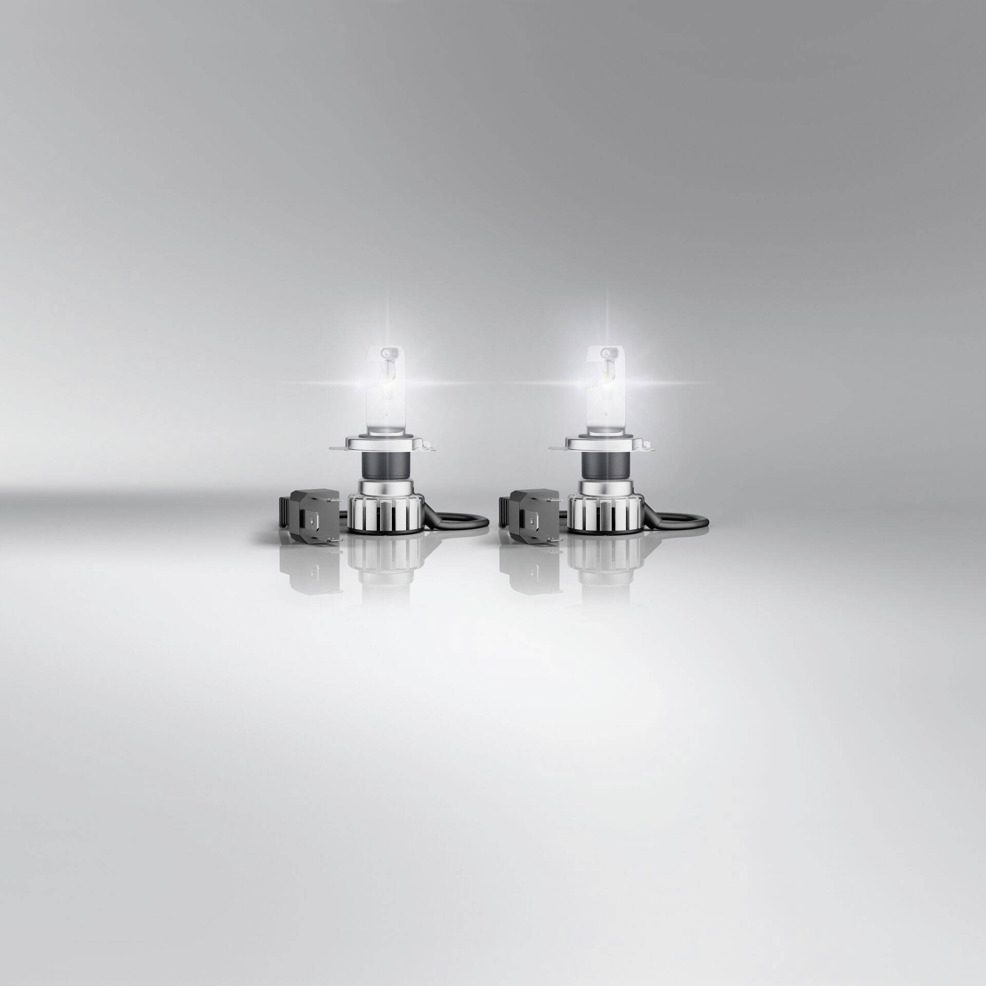 Deux lampes LED sur une surface lisse, illuminées et entourées d'un arrière-plan gris simple. Idéal pour un éclairage moderne.