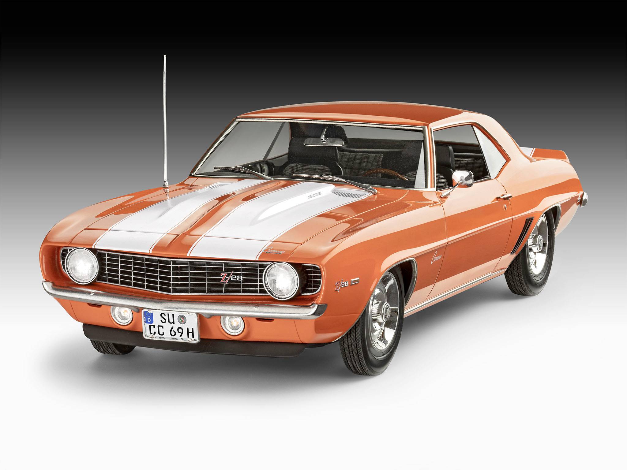 Une voiture de sport vintage orange et blanche, probablement un Chevrolet, présente un design élégant et classique à deux portes.