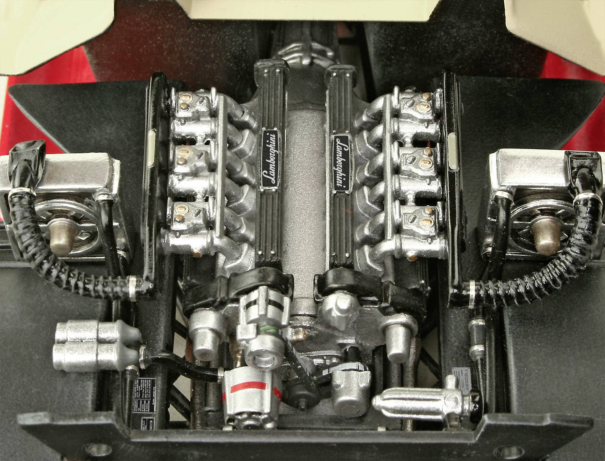 Modèle moteur d'une voiture de sport avec pistons et soupapes détaillés, portant l'inscription 'Lamborghini'.