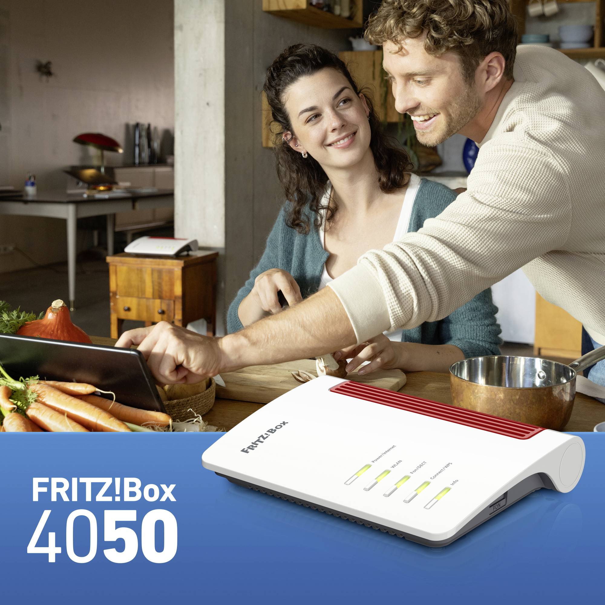 Un couple souriant dans une cuisine avec un FRITZ!Box 4050 au premier plan. Le FRITZ!Box présente plusieurs voyants lumineux.