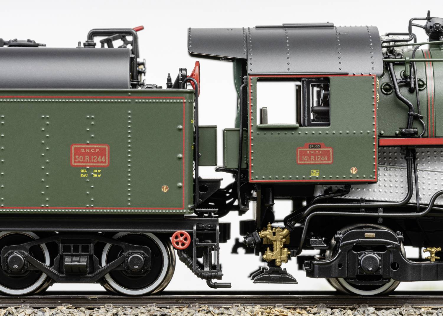 Gros plan d'un tender de locomotive à vapeur miniature, peint en vert détaillé avec des accents rouges et argentés.