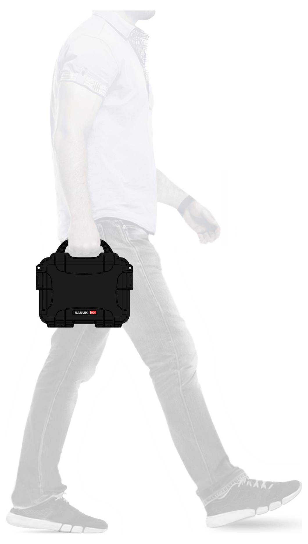 Une personne marche, tenant une valise noire dans sa main droite. L'accent est mis sur la valise.