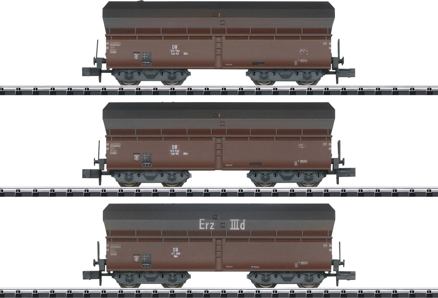 Trois wagons de marchandises bruns identiques sur des rails, vue latérale, chacun portant l'inscription 'Erz III d'.
