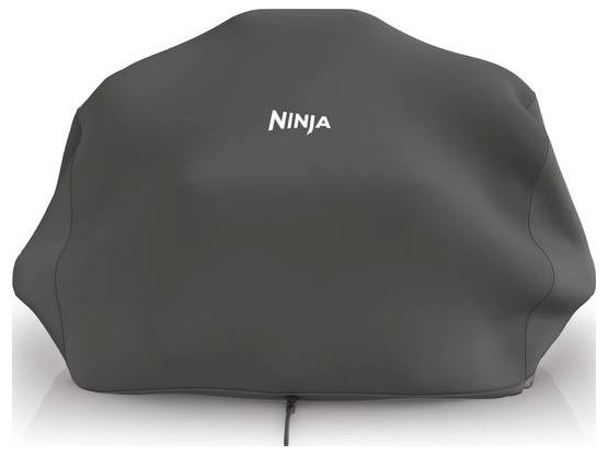 Un couvercle noir portant le mot 'Ninja' recouvre un grand appareil rectangulaire, probablement un barbecue ou un appareil de cuisine.