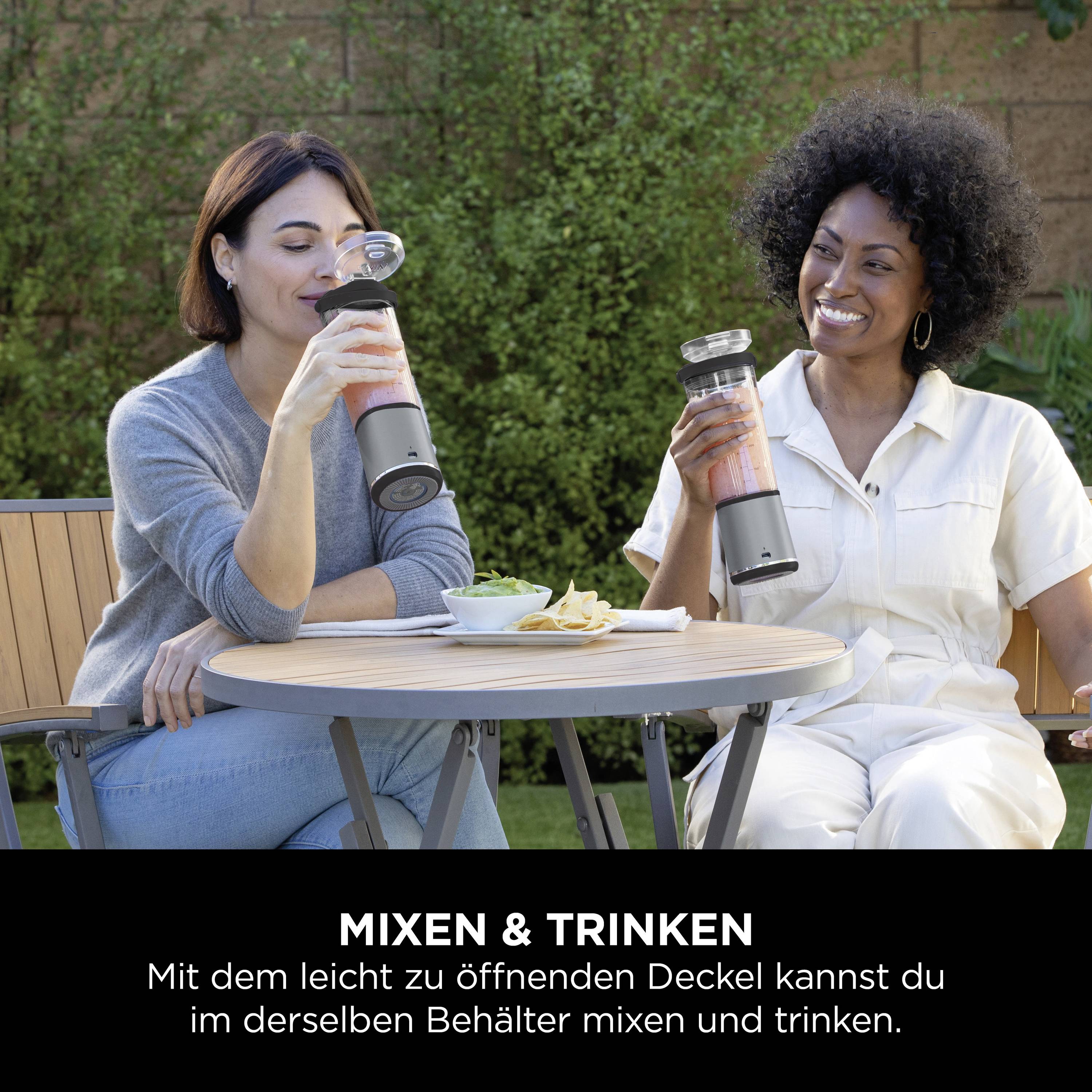 Deux femmes sont assises à l'extérieur à une table, tenant des bouteilles. Texte en dessous : 'Mixer & Boire. Avec le couvercle facile à ouvrir, vous pouvez mixer et boire dans le même récipient.'
