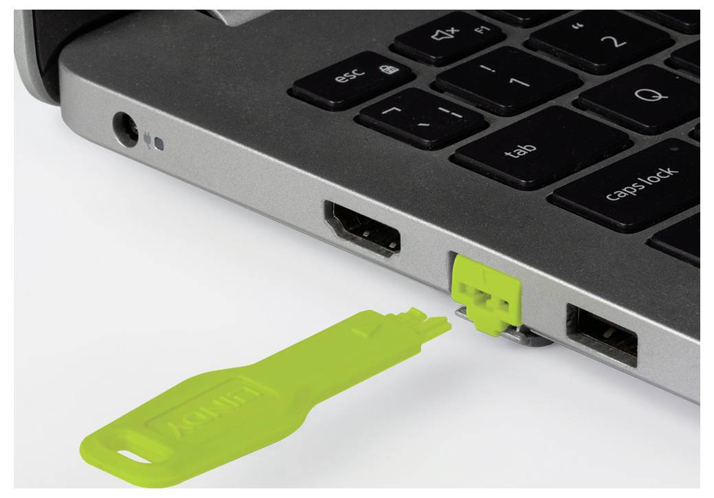 Une clé de sécurité USB verte est insérée dans le port USB d'un ordinateur portable, ce qui suggère une authentification à deux facteurs ou un accès au dispositif.