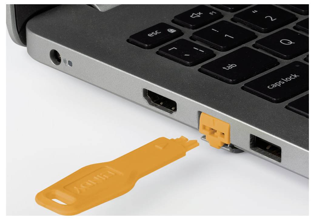 Orange USB adapter plugged into a laptop’s side port beside the keyboard, showing a connected device accessory.