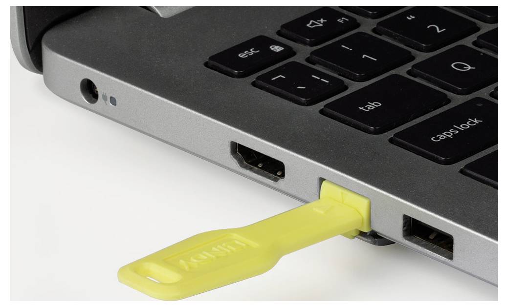 Clé USB jaune branchée sur le côté d'un ordinateur portable