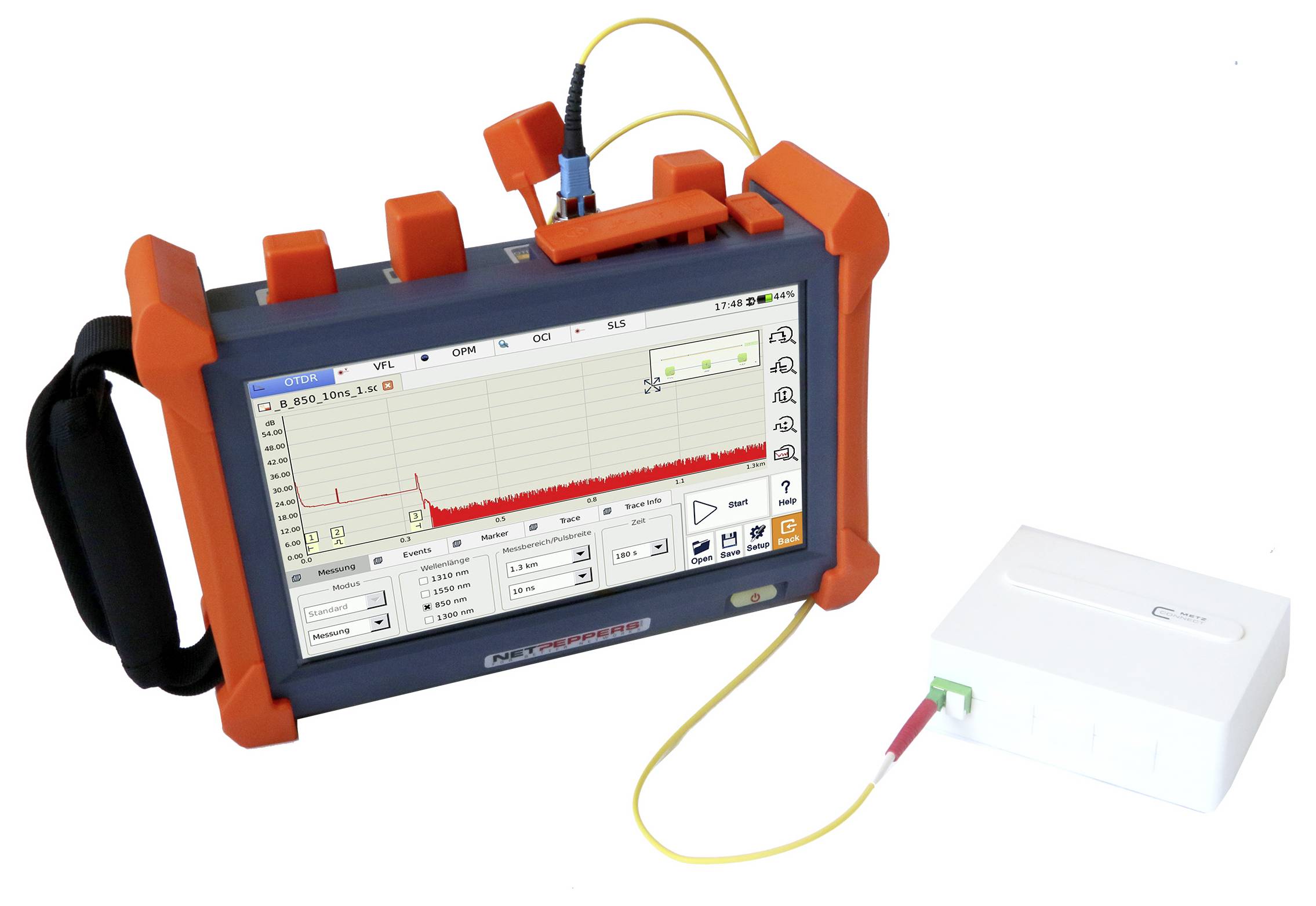 Un appareil de test portable pour l'analyse des fibres optiques, affichant un diagramme de signal sur un écran avec des bordures de protection orange.