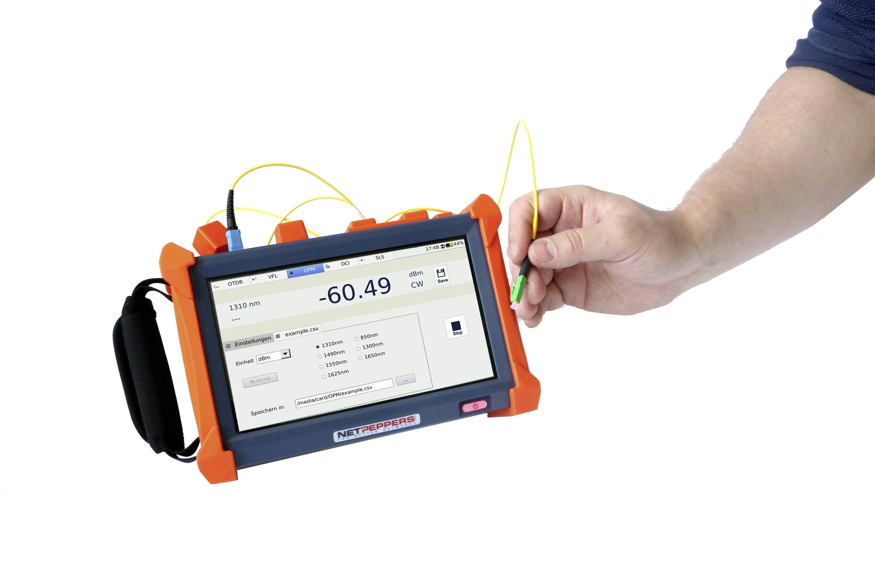 Un appareil de mesure portable affiche une valeur de -60,49 sur son écran. Une main tient un câble jaune qui est connecté à l'appareil.