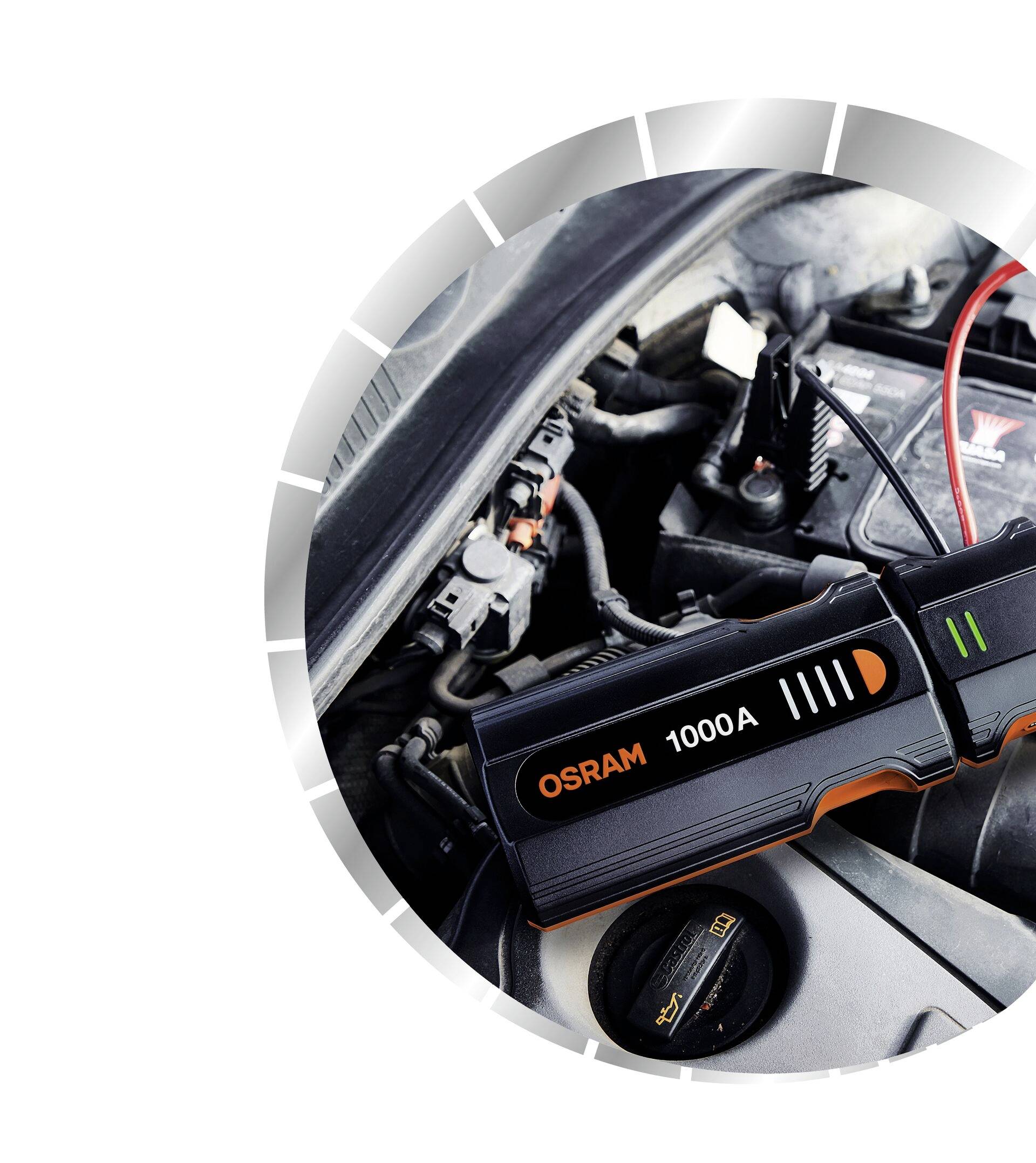 Un démarreur de batterie de voiture portant l'inscription 'OSRAM 1000A' est connecté à une batterie de voiture pour démarrer le moteur.