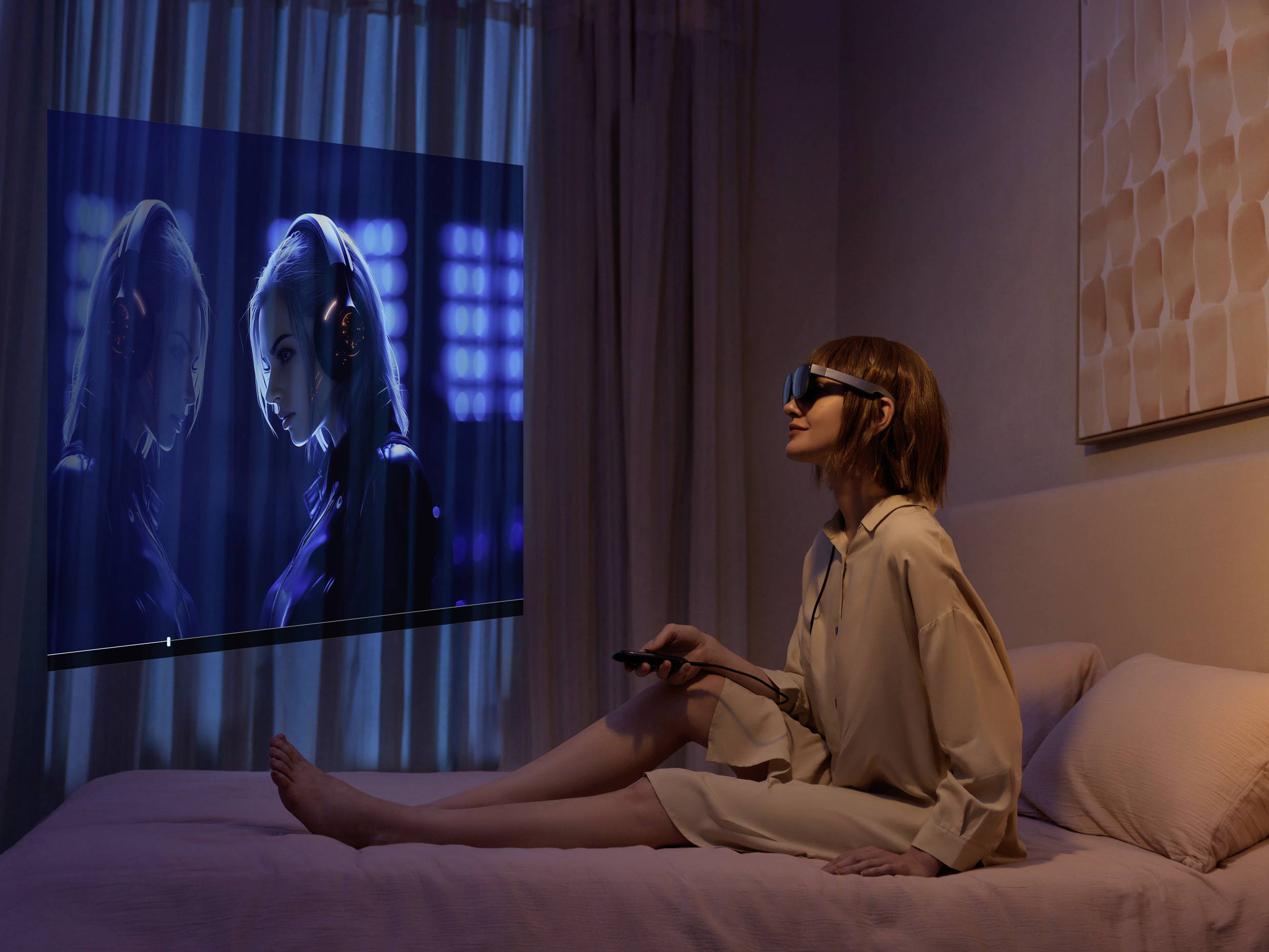 Une personne est assise sur un lit, porte un casque de réalité virtuelle et regarde une projection murale d'une vidéo aux couleurs bleues lumineuses.
