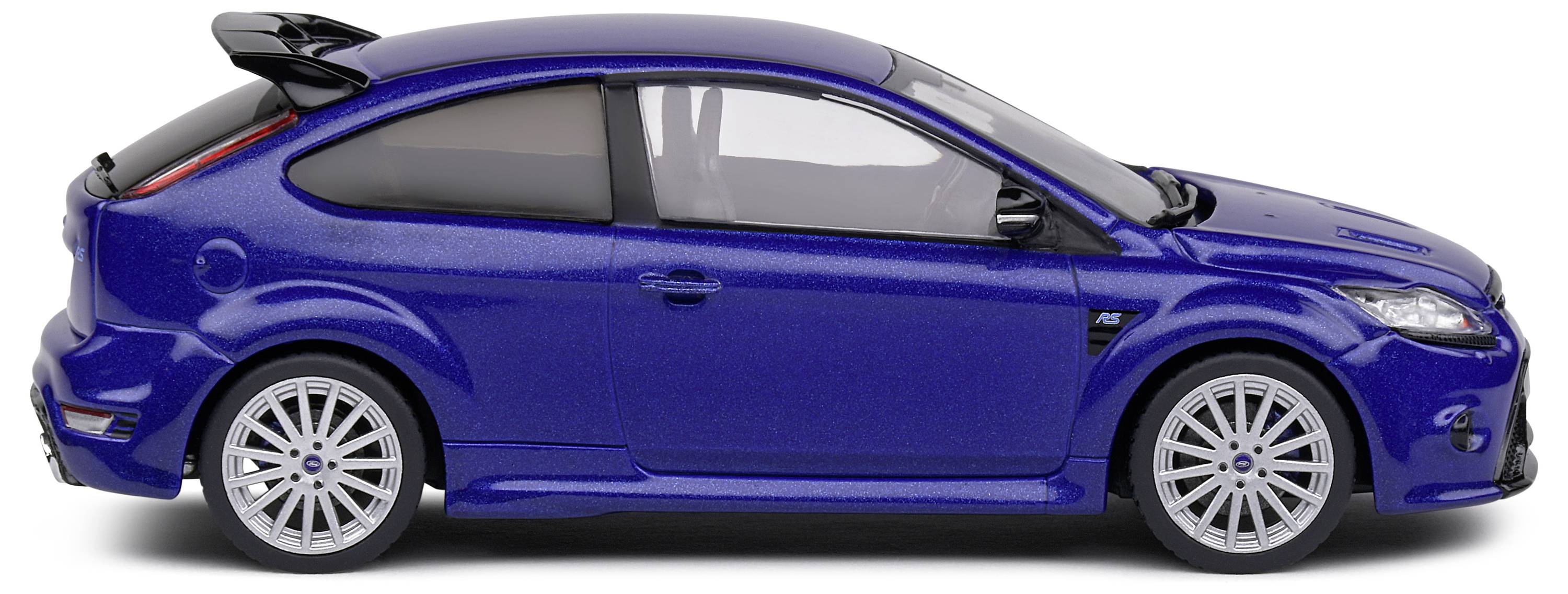 Une voiture miniature bleu foncé en vue latérale, avec une carrosserie de type sportive à hayon, un spoiler et des jantes argentées, sur un fond blanc.
