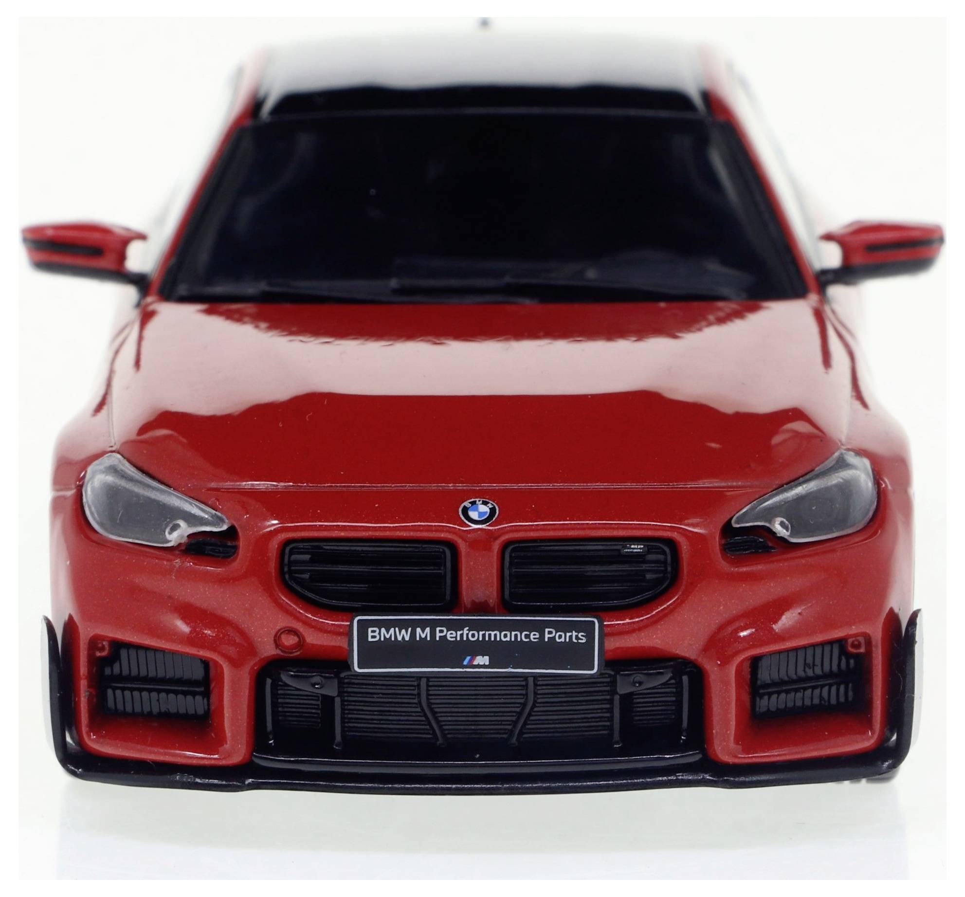 BMW rouge avec l'emblème 'BMW M Performance Parts'. Vue du véhicule de face, mettant l'accent sur le design et la marque.