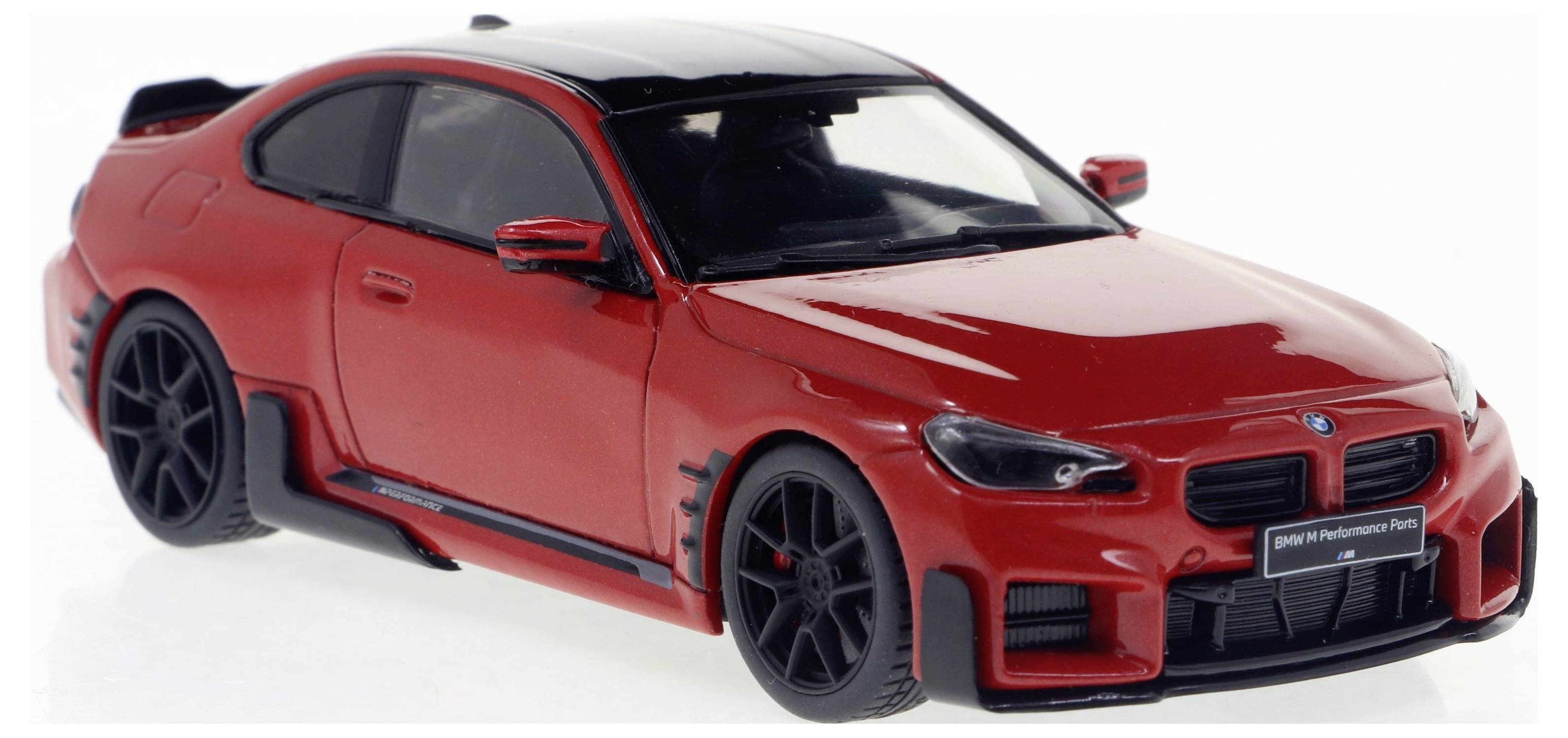 Voiture miniature rouge d'un coupé sportif avec des jantes noires et des détails. La voiture présente un toit noir et un design dynamique.