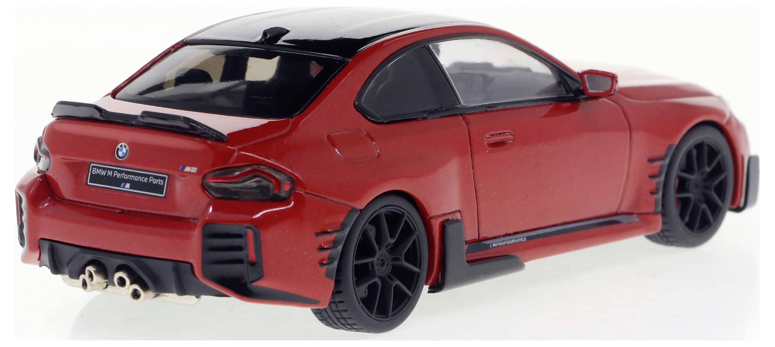 Une voiture de jouet rouge, modèle d'une voiture de sport, avec un toit noir et des feux arrière distinctifs, est posée sur un fond blanc.