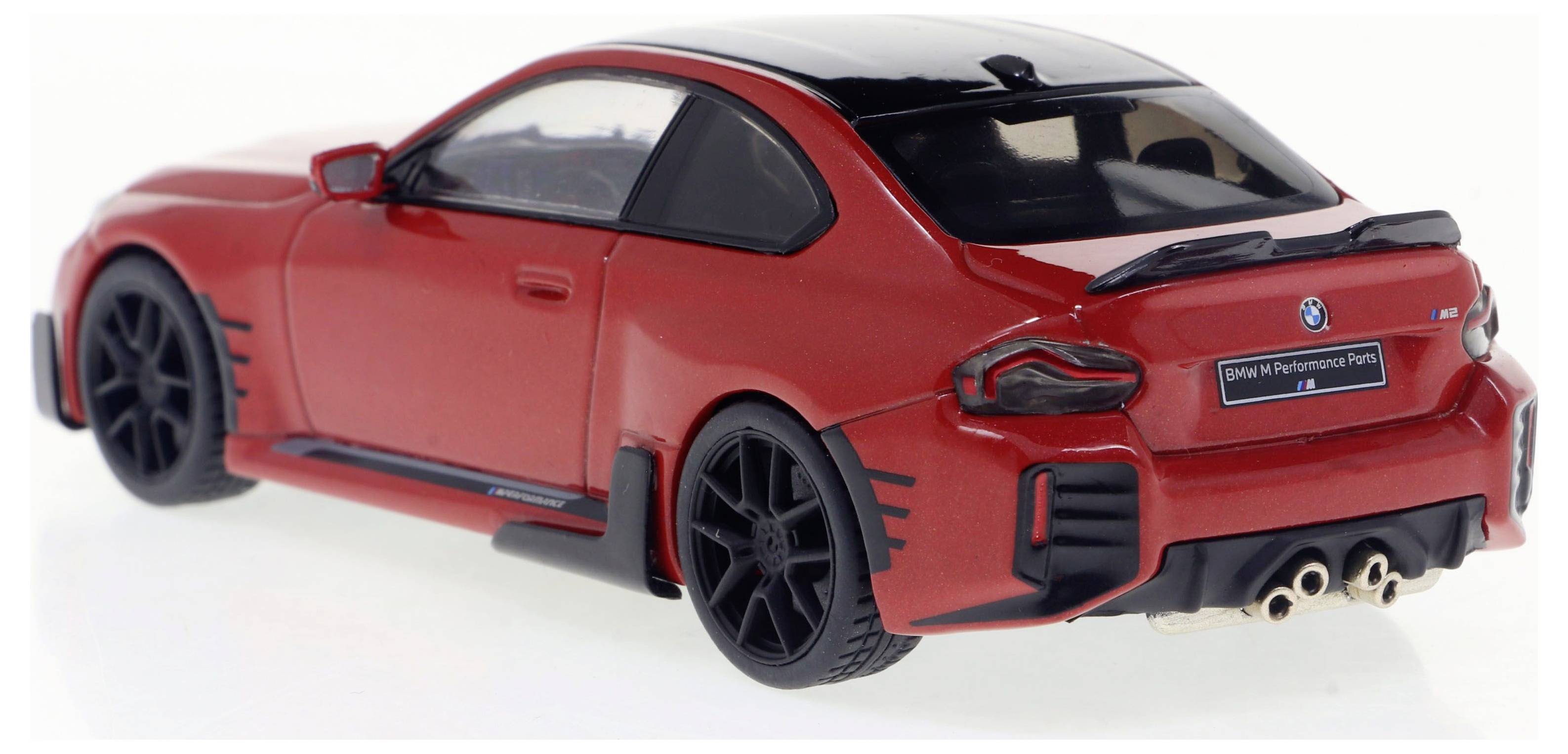 Voiture miniature rouge vue de côté. Style sportif avec jantes noires et entrées d'air marquantes.