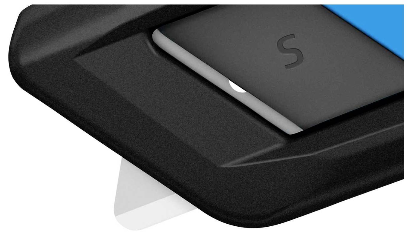 Gros plan d'une partie d'un boîtier contenant un objet incrusté portant la lettre 'S'.