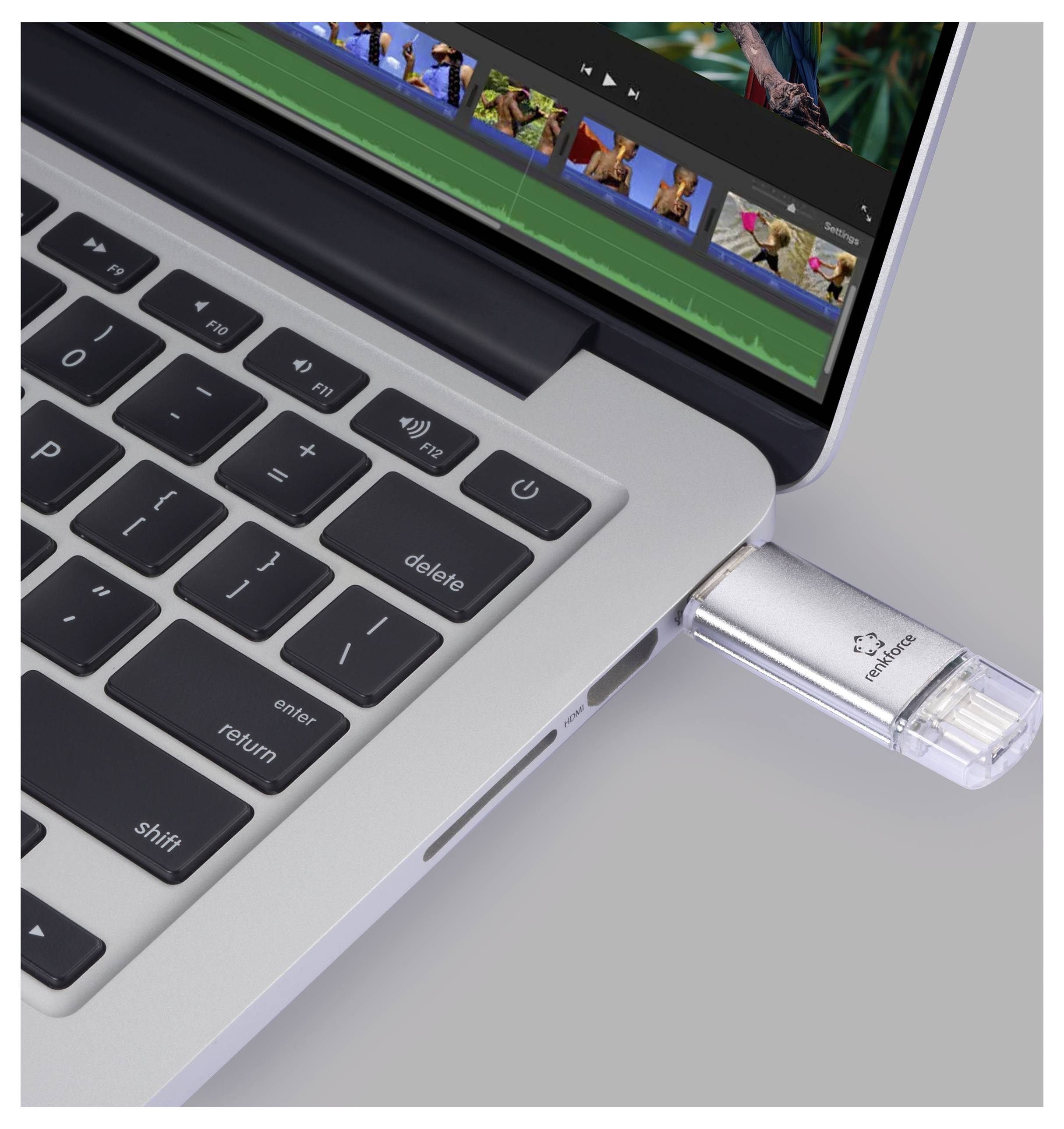 Gros plan d'un ordinateur portable avec une clé USB branchée dans le port latéral, affichant des vignettes de fichiers à l'écran.