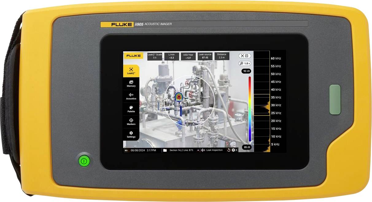 Un appareil de mesure portable jaune avec un écran affiche une machine. L'écran représente visuellement différentes données acoustiques mesurées.