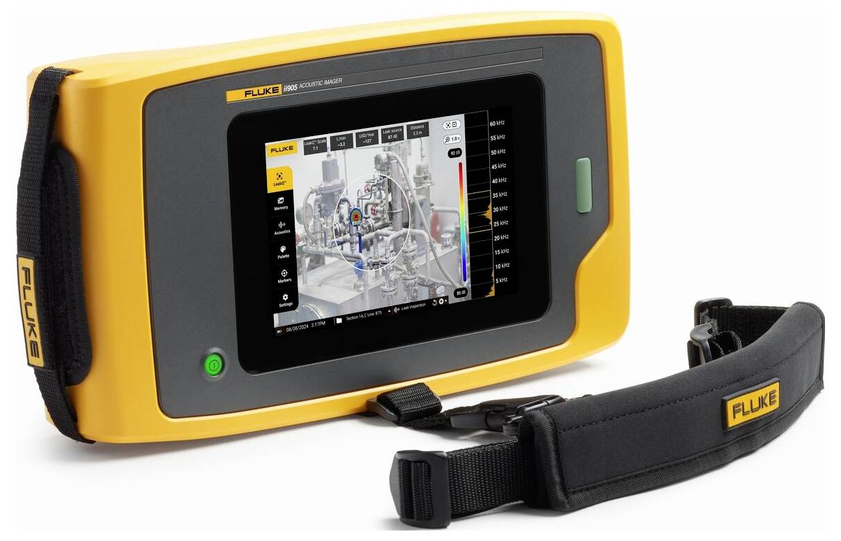 Un appareil de mesure portable jaune avec un écran affiche des données techniques. Il est équipé d'une sangle noire pour le transport.