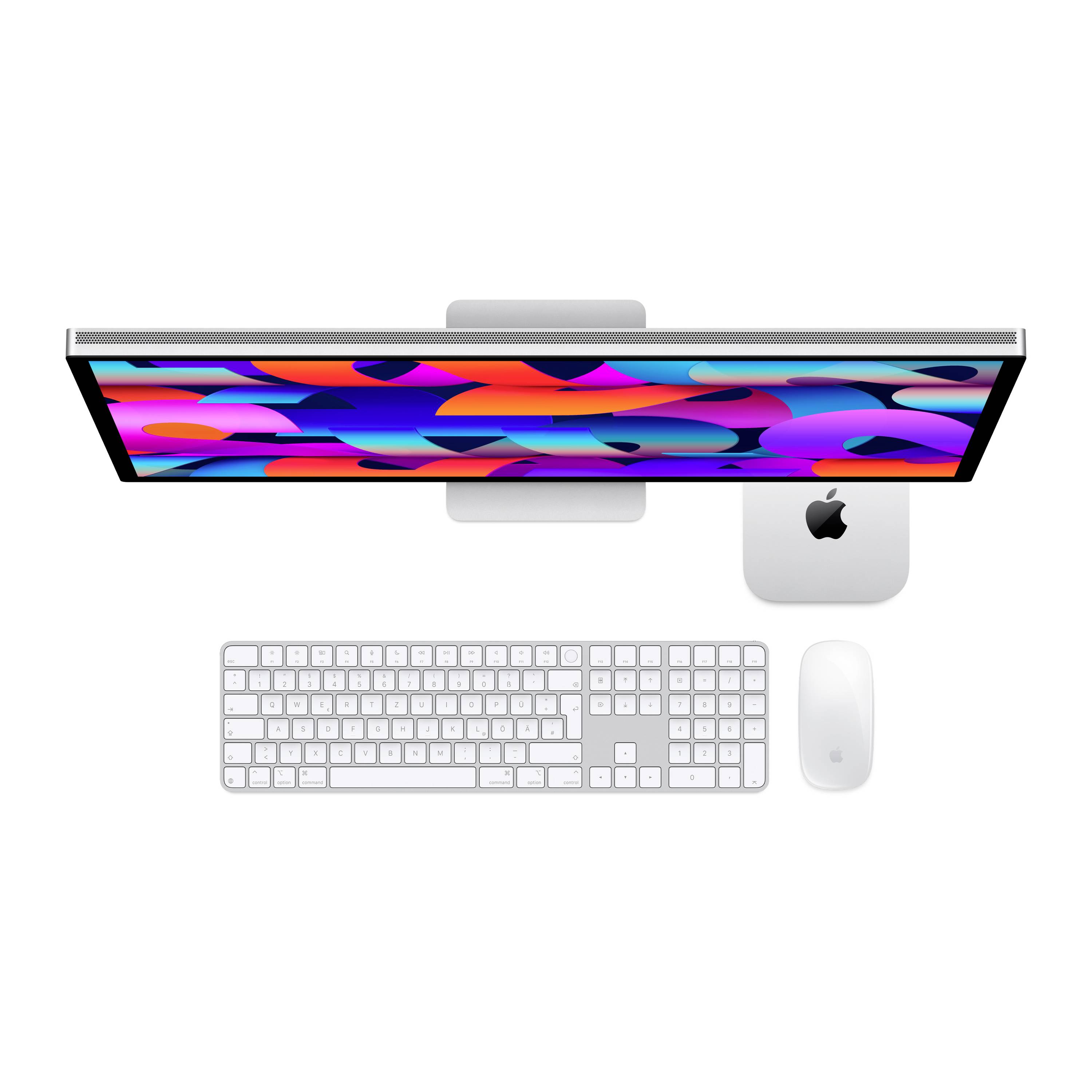 Un ordinateur de bureau moderne avec clavier et souris. L'écran affiche un design abstrait et coloré.