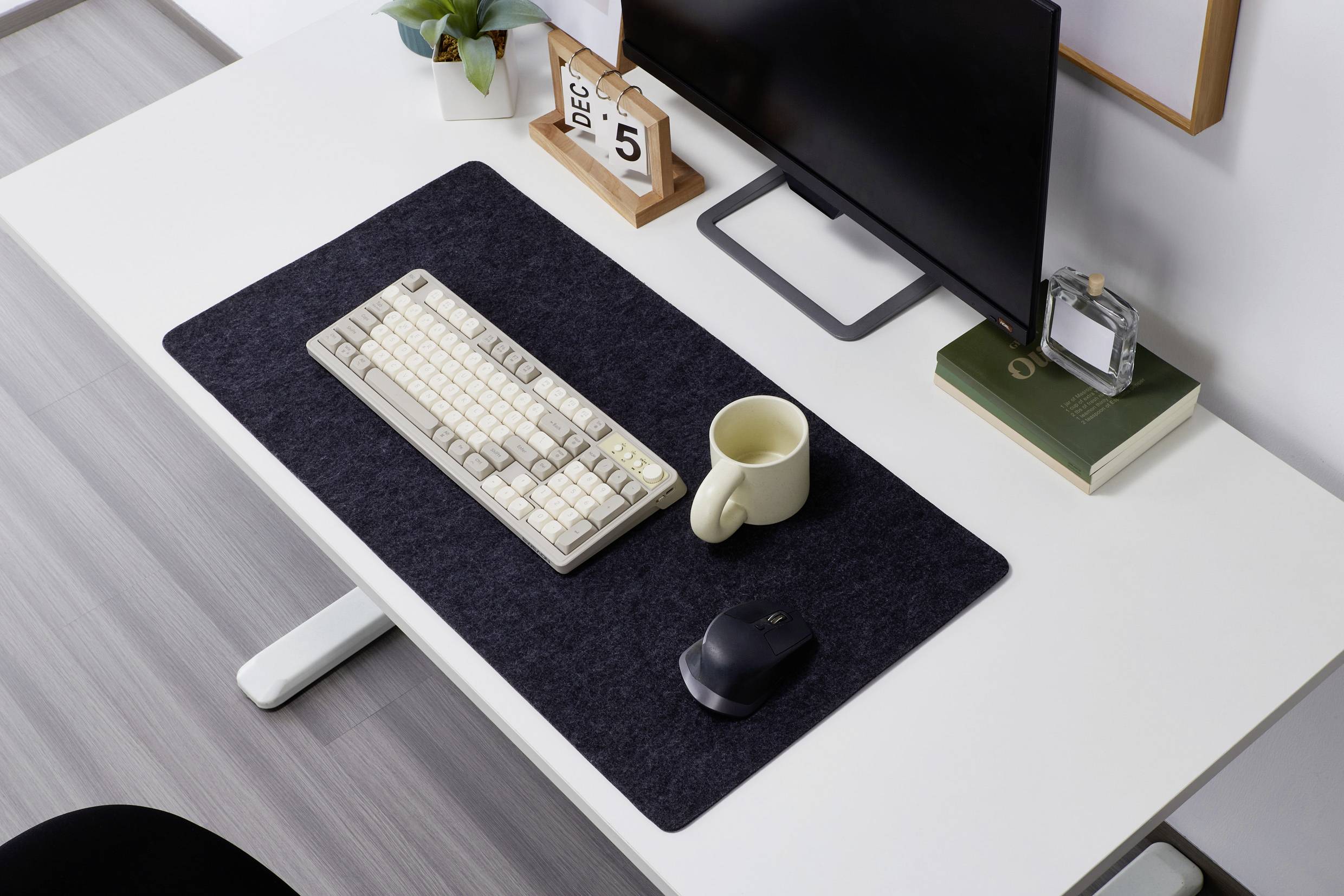 Un clavier, une souris, une tasse et un écran sont posés sur un bureau. Un calendrier indique la date du 5 décembre.