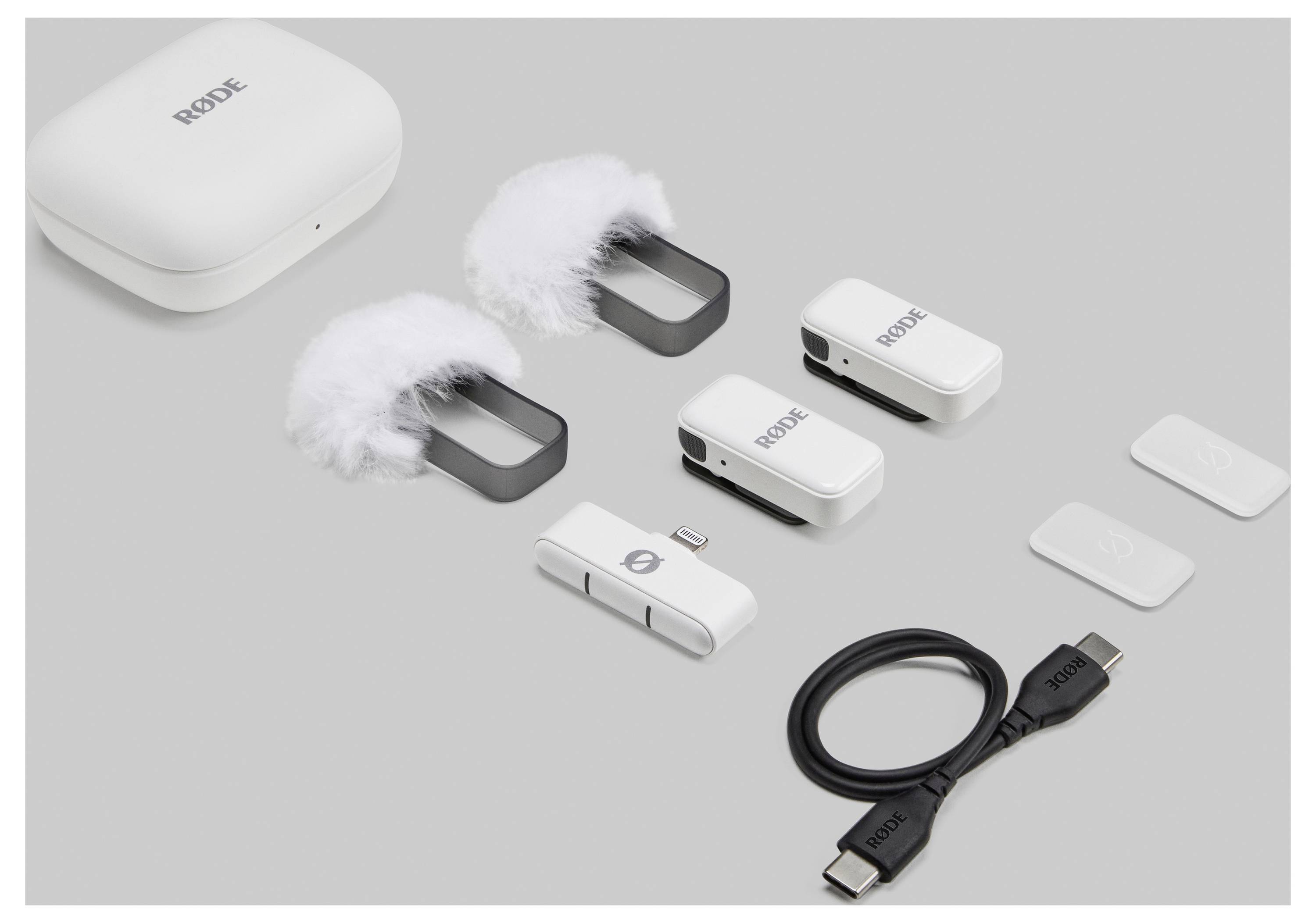 Ensemble de microphones sans fil 'Rode Wireless GO II' comprenant deux émetteurs, un récepteur, deux bonnettes pare-vent, un câble USB et un étui de charge.
